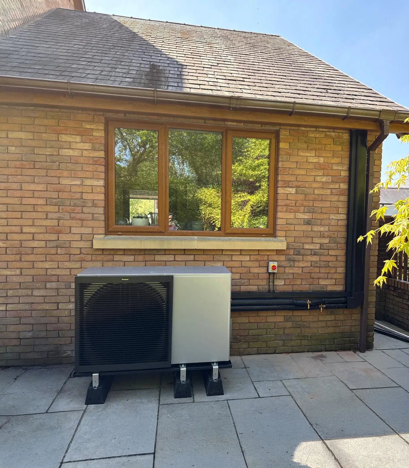 Daikin Altherma 3 H HT heat pump unit neatly sited at the side of a property in Ware